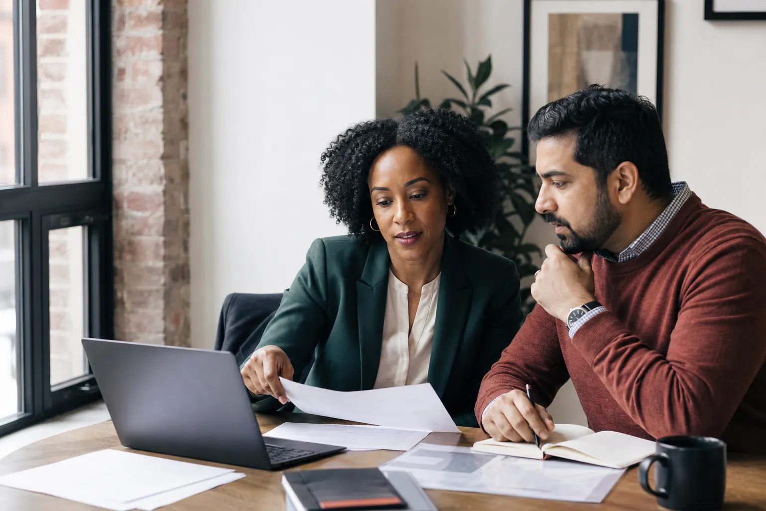 Two small-business leaders reviewing a proposal strategy together
